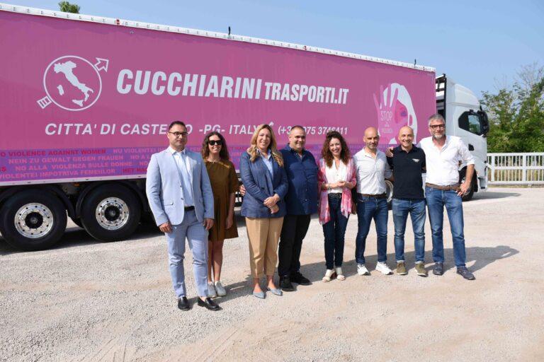Rosa “on the road”: fiocco rosso ed una scritta in tutte le lingue per dire no alla violenza di genere sul telo del semirimorchio di un camion colorato di rosa