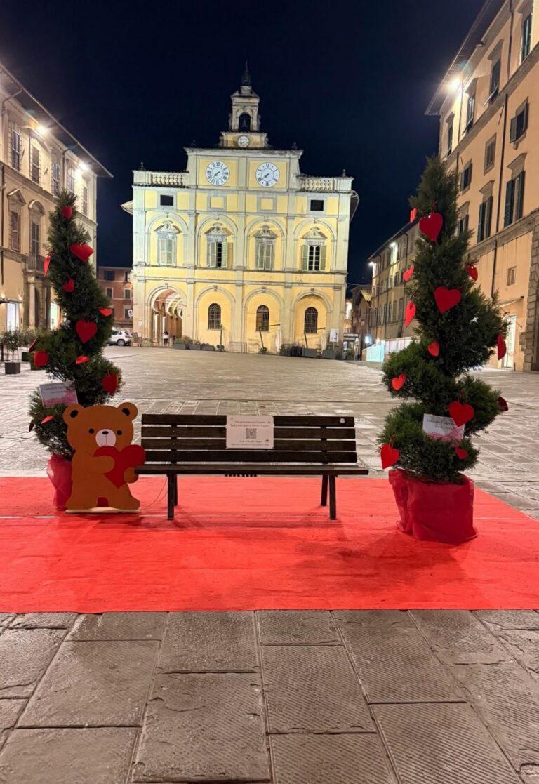 La panchina del “cuore, della solidarietà, contro ogni forma di violenza in piazza Matteotti a disposizione per foto e messaggi con uno sfondo “mozzafiato”, la facciata del palazzo del Podestà e l’orologio a due quadranti monumento simbolo della città